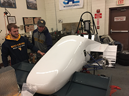 Ian Smithson and Logan Horn admire car 87's new bodywork manufactured with the generous support of Aurora Flight Science of Bridgeport WV.