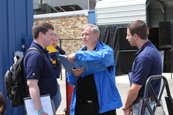 Justin Fitzwater and Howard Bugg talk to lead design judge Claude Rouelle during the Design Event at the 2014 Formula SAE® Michigan Competition